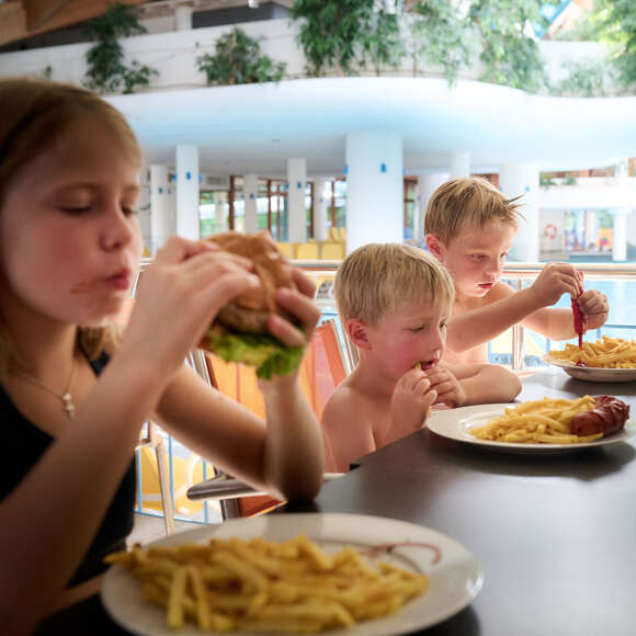 Kinder essen Pommes und Burger im Aquaria Bistro