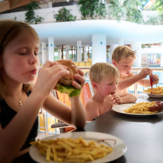 Kinder essen Pommes und Burger im Aquaria Bistro