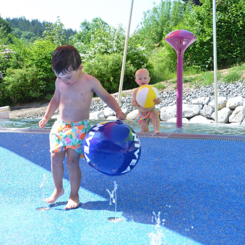 Spielen mit Wasser und Wasserball im Kinderbecken im Aquaria-Außenbereich